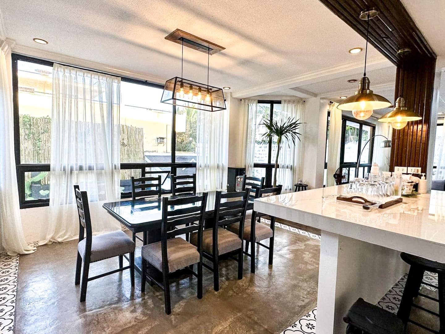 The dining table by the window under a wire chandelier